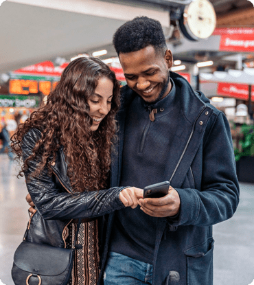 A couple looking at a phone, representing reaching your audience with enhanced customer insights.