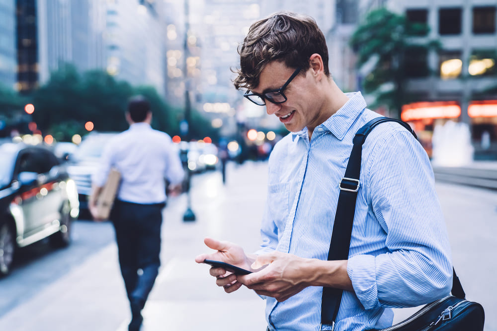 A man looking at his phone, representing social media advertising